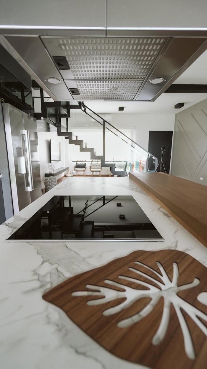 A sleek, contemporary kitchen design featuring marble countertops and a stylish induction cooktop.